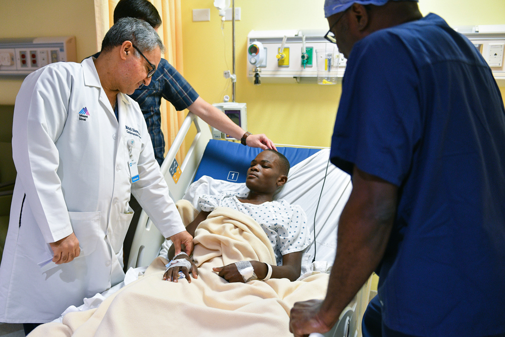 Dr. Mehdi Oloomi monitors a young patient in the intensive care unit after mitral valve repair surgery during a Mitral Foundation Children's Valve Project medical mission to the Dominican Republic.