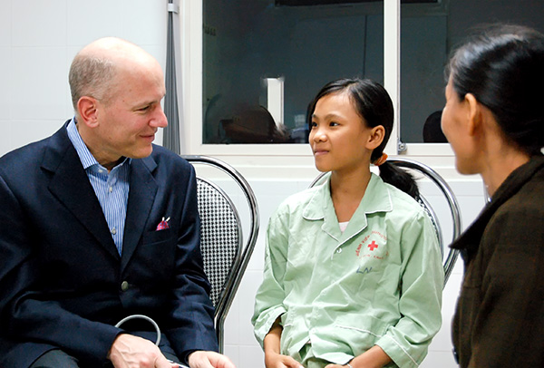 Dr. Adams meets with a patient during their recovery from mitral valve repair on a 2009 medical misison to Vietnam.
