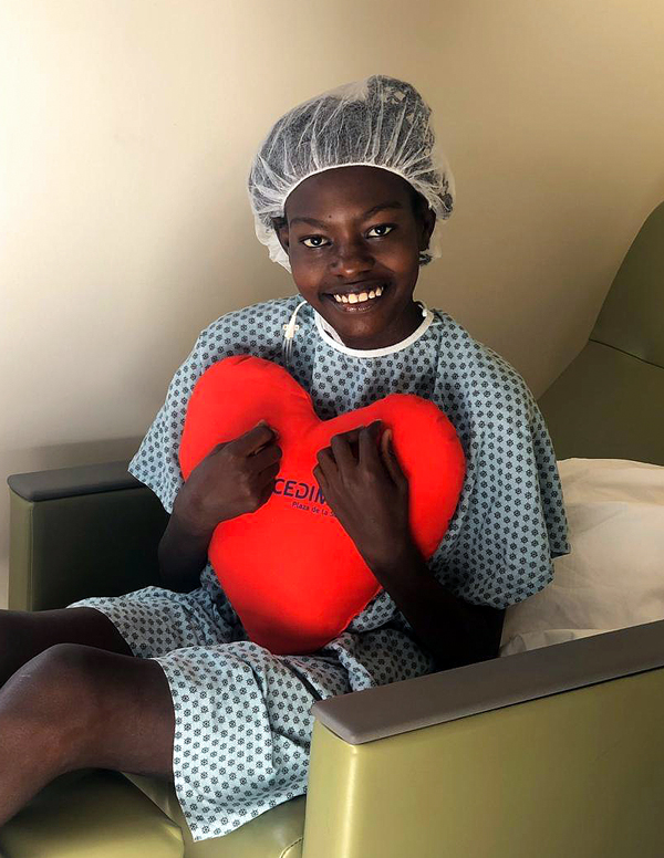 Wideline poses with a heart pillow after her successful mitral valve repair surgery.