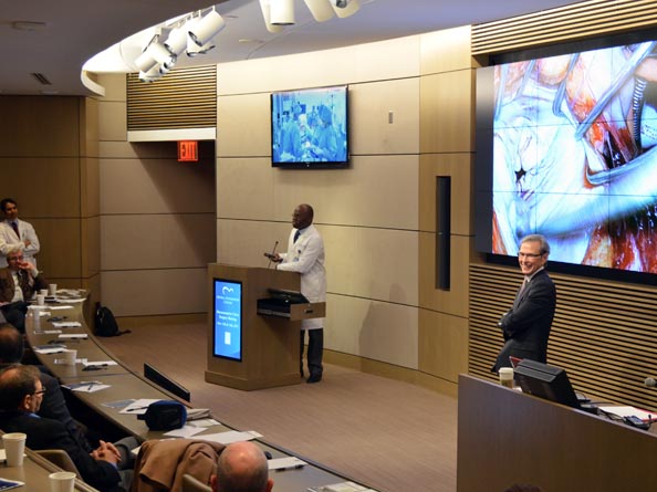 Dr. Ani Anyanwu (left) and Dr. Randy Martin (right) moderate while Dr. Adams performs live mitral valve repair surgery.